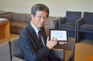 ipadを手に電子書籍について語る田村所長